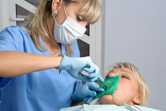 dentist using a rubber dam in a patient's mouth